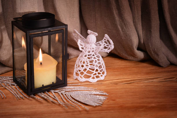 istock Christmas decorations on black background. White crochet angel, lantern, candle, silver feather and beads 1071744672