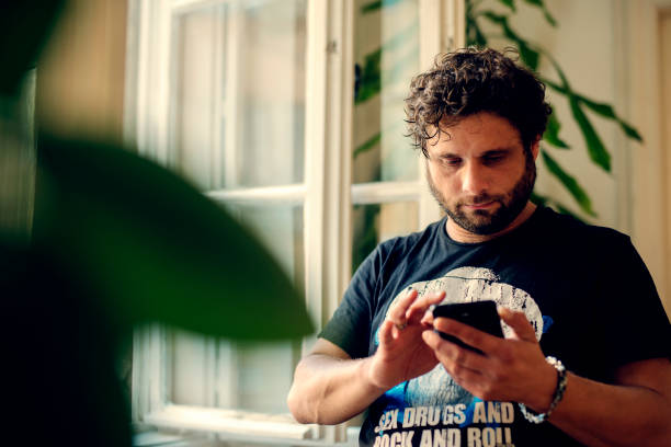istock Cheerful young man texting and browsing the internet on his smart phone 1071751076