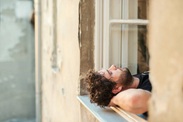 istock Cheerful young man laying outside on the window taking a break 1071751362