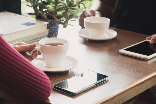 istock Female's hand holding a tea cup on wooden table. 1071751406