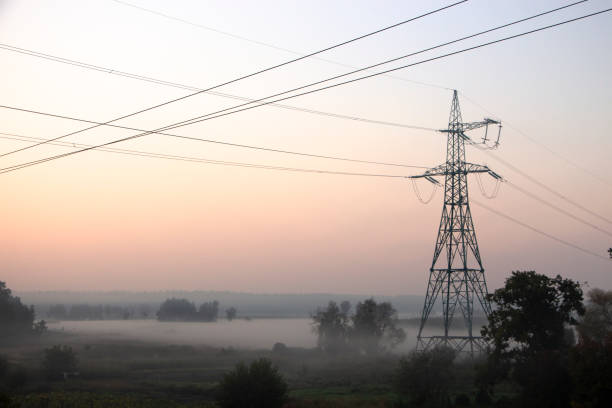 istock High voltage electricity transfer lines and pylon in a fog 1071752842