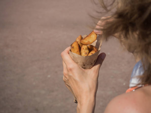 istock Potato snacks in the hands on the square. 1071754784