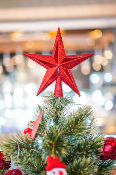 istock Red star decoration on the three with blur big Christmas tree behide. 1071761996