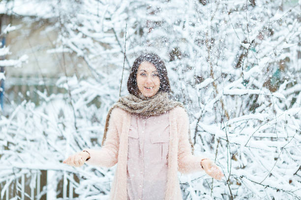 istock cute girl plays with falling snow in the winter forest 1071762096