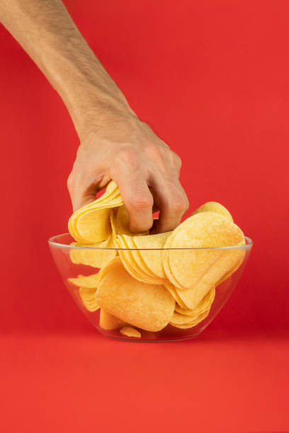 istock Grabbing potato chips from a glass bowl 1071768446