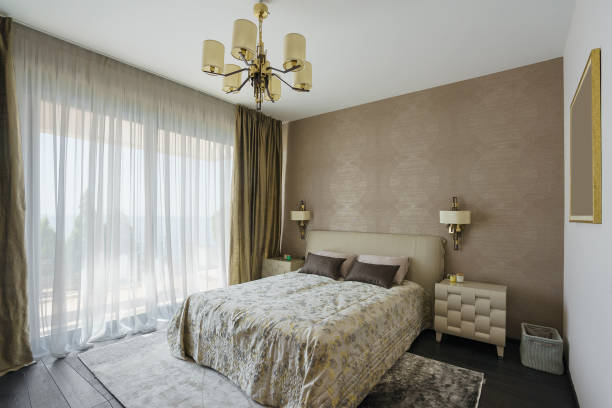 istock Interior of a spacious light bedroom with windows in a luxury villa. Big comfortable double bed in elegant modern bedroom 1071773866