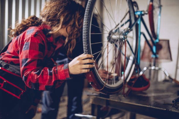 istock Man and woman repairing bicycle in workshop 1071774178