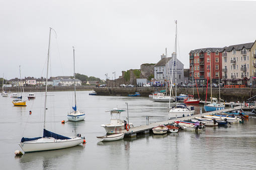 Dungarvan, Republic of Ireland - August 15th 2018: Vessels moored at the harbour in the coastal town of Dungarvan, in County Waterford, Republic of Ireland.  Dungarvan Castle is in the background.