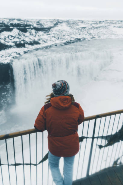 istock Woman looking at  Dettifoss waterfall in winter 1071778440