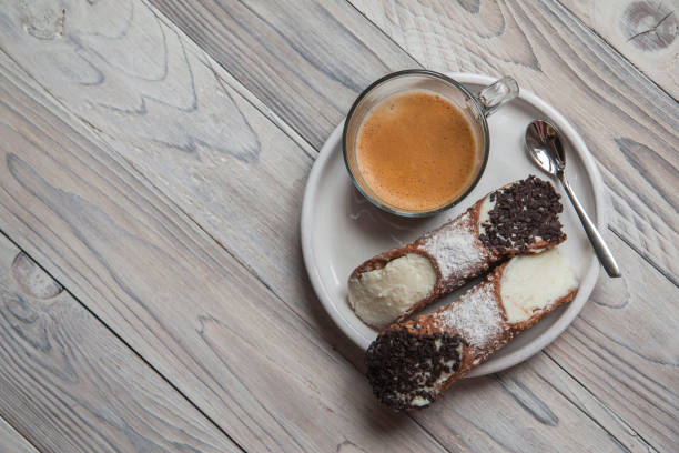 Breakfast with coffee and Cannoli Breakfast with coffee and Cannoli - Italian pastries, a staple of Sicilian cuisine, with creamy filling usually containing ricotta. cannoli photos stock pictures, royalty-free photos & images