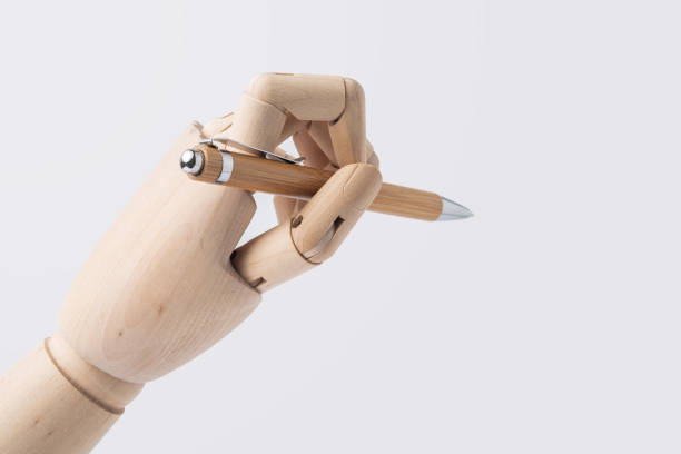 istock wooden hand hold pen isolated on white background 1071782200