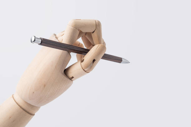 istock wooden hand hold pen isolated on white background 1071782246