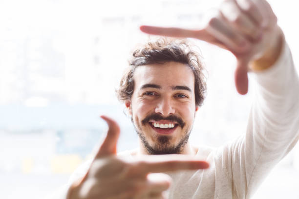 男の手を笑顔のフレーミング - 指のフレーム ストックフォトと画像