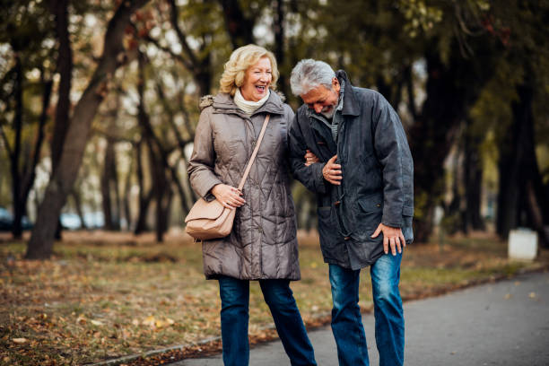 istock Senior couple walking in a park and smiling 1071795528