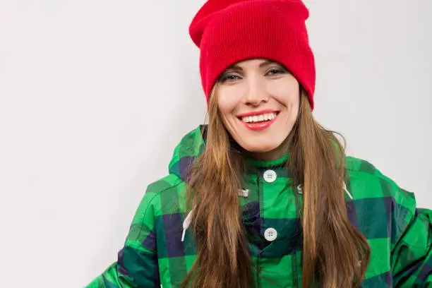 Young woman wearing bright wintersport coat and knitted hat