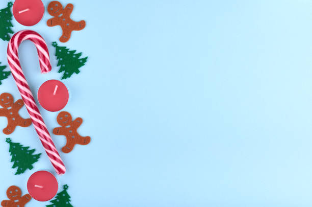 istock New Year composition with striped candy, pine tree, candle and gingerbread man. Christmas concept background. Flat lay, top view of festive still life 1071801888
