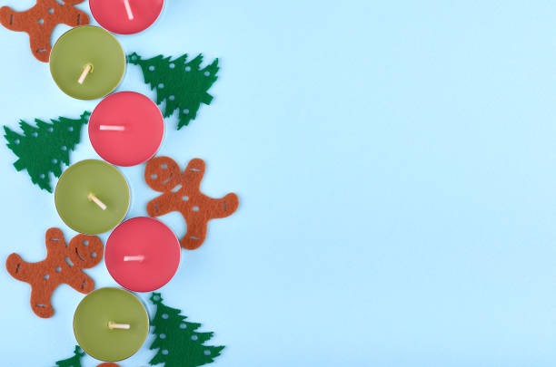 New Year composition with candles, pine tree and gingerbread man. Christmas concept background. Flat lay, top view of festive still life.