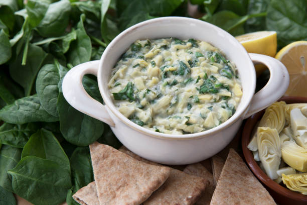 Spinach Artichoke Dip with Fresh Ingredients Bowl of vegan spinach artichoke dip with pita and ingredients. dipping sauce stock pictures, royalty-free photos & images