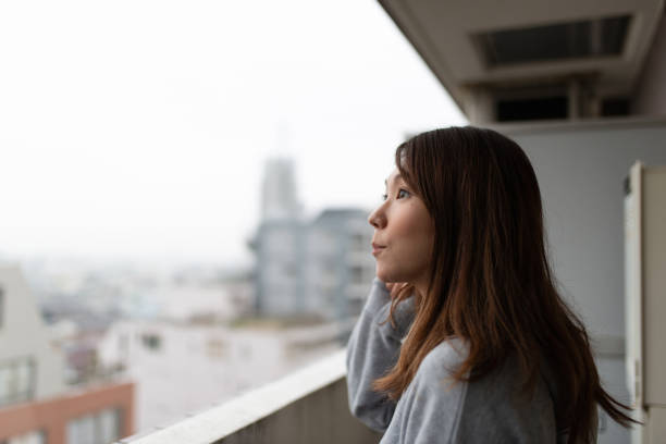 istock Woman looking out from balcony 1071805544