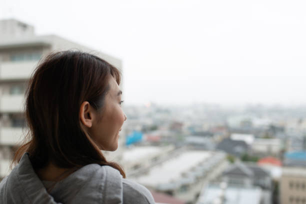 istock Woman looking out from balcony 1071805586