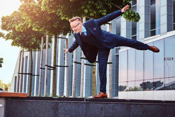 istock Joyful stylish businessman dressed in elegant suit have fun while standing outdoors against skyscraper background. 1071808560