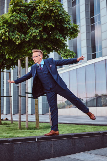 istock Stylish businessman dressed in an elegant suit have fun while standing outdoors against a skyscraper background. 1071808930