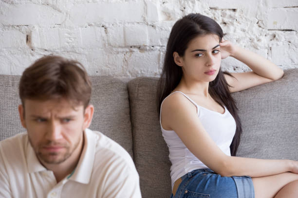 istock Offended frustrated girlfriend looking at sitting separately boyfriend 1071821916