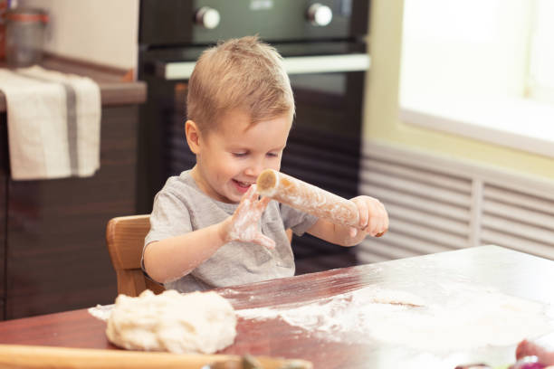 istock Little kid boy making pizza or pasta dough smeary with flour 1071824066