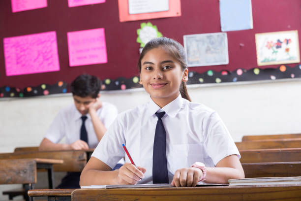 istock Female student in classroom writing in notebook - Stock image 1071826298