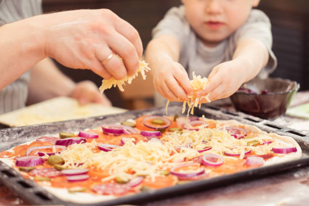 お父さんと息子の自宅にピザを料理 - tomato sauce domestic kitchen meat cheese ストックフォトと画像