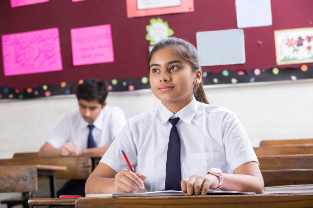 istock Female student in classroom writing in notebook - Stock image 1071827038