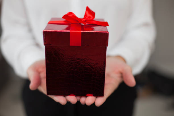 istock Female Hands Holding a Red Gift Box 1071875394