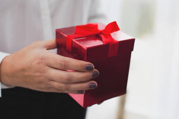 istock Female Hands Holding a Red Gift Box 1071876108