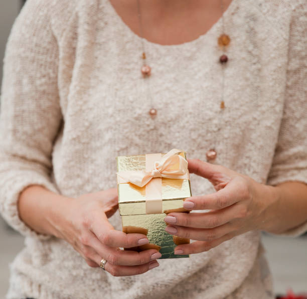 istock Unrecognizable Woman Holding a Golden Gift Box 1071876618