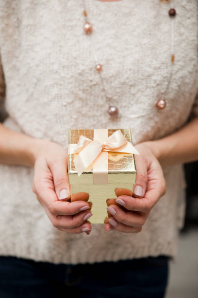istock Unrecognizable Woman Holding a Golden Gift Box 1071876642