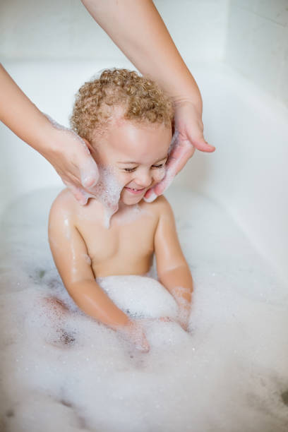 istock Cute two year old boy taking a relaxing bath with foam 1071877390