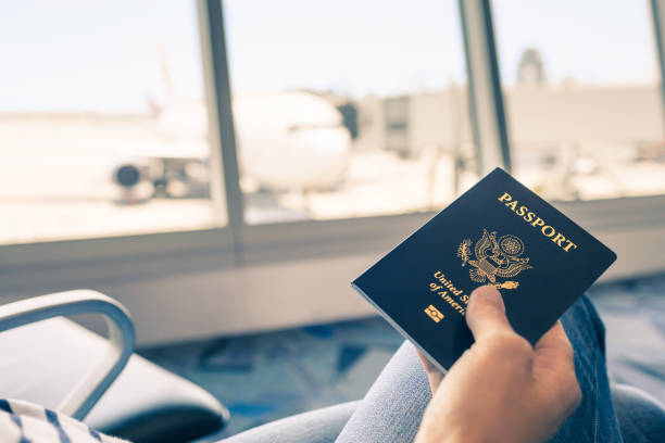 Hand holding US passport. Traveler at airport holding United States passport in hand. customs official photos stock pictures, royalty-free photos & images
