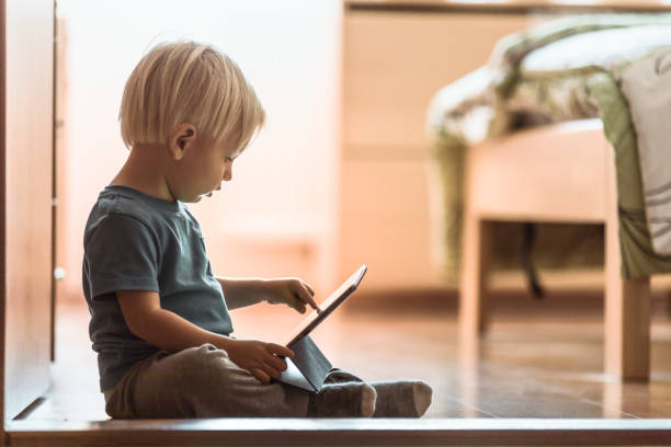 mały chłopiec za pomocą inteligentnego tabletu w domu. - ipad baby boys little boys caucasian zdjęcia i obrazy z banku zdjęć