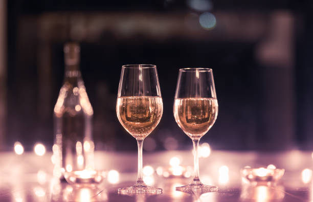 pair of wine glasses surrounded by candle lights. - restaurant wine table table for two imagens e fotografias de stock