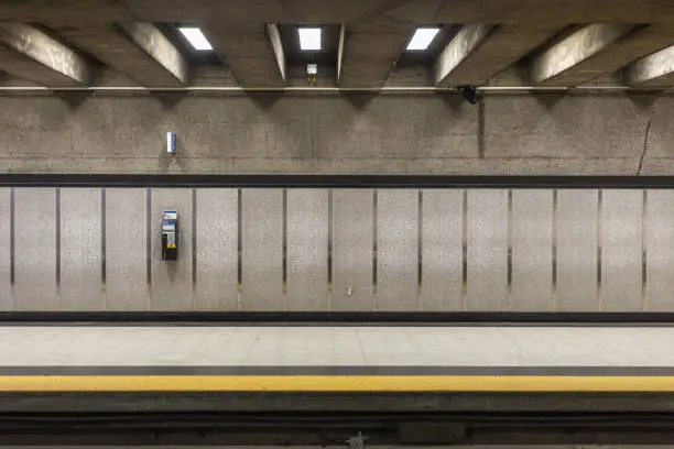 Photo of A lonely phone attached to tiled wall with ceiling beams