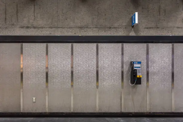 Photo of Payphone attached to wall with silver stripes