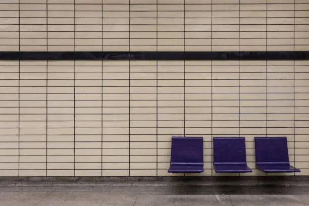 Photo of Purple chairs attached to tiled wall