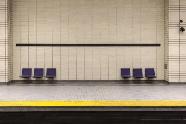 Photo of Two sets of purple chairs attached to tiled wall