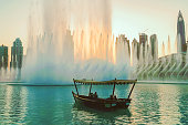 Dubai promenade singing fountains on the background of architecture.