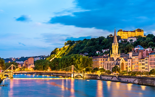 St. George Church and a footbridge across the Saone in Lyon at sunset. France