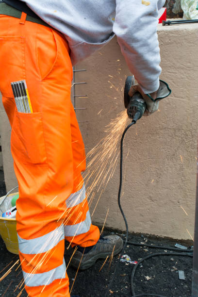 istock Worker using an Orbital Grinder on Steel Surface wearing Orange Work Trousers and Safety Tools 1071913620