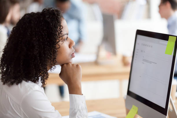 istock Thoughtful black female employee thinking writing business email 1071915498