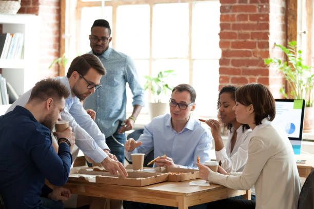 istock Diverse colleagues enjoy pizza having lunch break in office 1071915656