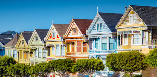 Painted Ladies at Alamo Square, San Francisco, California, USA Classic postcard view of famous Painted Ladies, a row of colorful Victorian houses located near scenic Alamo Square, on a beautiful sunny day with blue sky in summer, San Francisco, California, USA row house photos stock pictures, royalty-free photos & images