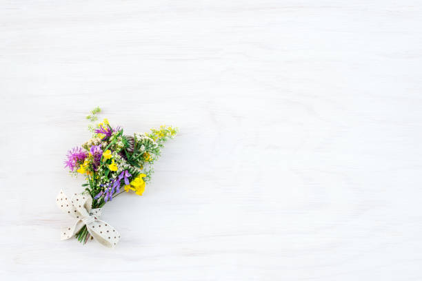 bouquet di fiori selvatici su sfondo bianco in legno - small bouquet foto e immagini stock